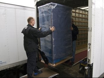 The Worker carefully moving the shipments from one to another, OR.